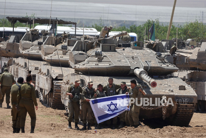  A group of Israeli soldiers holds an Israeli flag as they gather with military vehicles at an undisclosed position near the border fence with the Gaza Strip, in southern Israel, 09 May 2024. US Defense Secretary Austin at a Senate Appropriations Committee meeting on 08 May confirmed the Biden administration