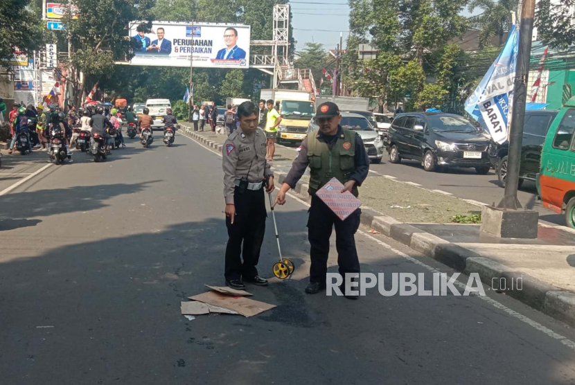 Petugas kepolisian tengah melakukan olah TKP seorang pengendara sepeda listrik yang tewas akibat terlindas truk sampah di Jalan Dago Bandung, Sabtu (5/8/2023). 