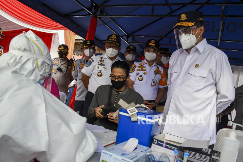 Menteri Perhubungan Budi Karya Sumadi (tengah) menyaksikan pemeriksaan tes cepat antigen untuk calon penumpang bus Angkutan Kota Antar Provinsi (AKAP) saat meninjau arus mudik Natal dan Tahun Baru 2021 (Nataru) di Terminal Kampung Rambutan, Jakarta, Rabu (23/12/2020). Menhub meninjau Terminal Kampung Rambutan untuk memastikan arus mudik Nataru berjalan maksimal dan sesuai dengan protokol kesehatan. 