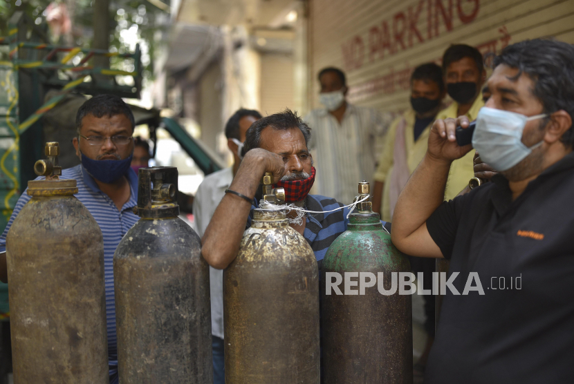 Sejumlah warga menunggu untuk mengisi tabung oksigen di New Delhi, India, Kamis (29/4). 
