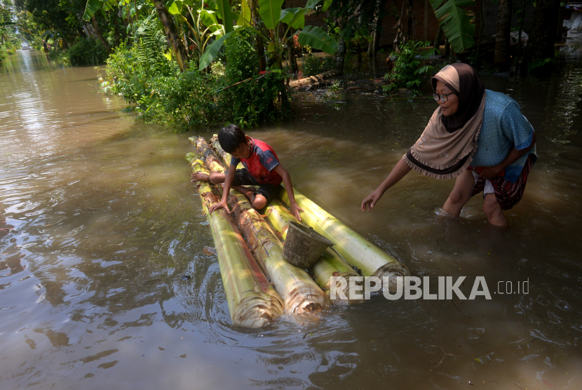 Warga bermain rakit saat banjir di Desa Kedungmulyo, Butuh, Purworejo, Jawa Tengah, Rabu (16/3/2022). Desa Kedungmulyo terendam banjir sejak Selasa (12/3/2022) sore imbas hujan deras semalaman. Akibatnya sekitar 140 warga harus mengungsi di Balai Desa Kedungmulyo. Meskipun daerah ini langganan banjir, banjir kali ini termasuk cukup besar dibandingkan tahun-tahun sebelumnya. Masyarakat Diminta Waspada, Jawa Tengah akan Dilanda Cuaca Ekstrem 19-21 Mei