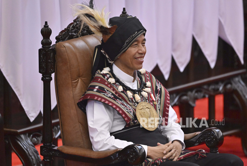 Indonesian President Joko Widodo, wearing traditional attire from Tanimbar Islands of Maluku province, takes his seat before delivering his State of the Nation Address ahead of the country