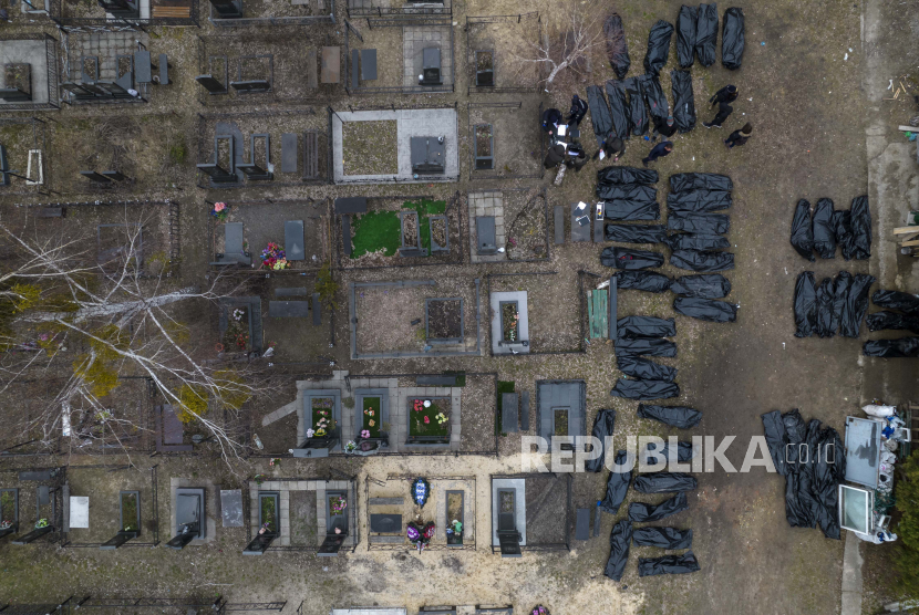 Polisi bekerja untuk mengidentifikasi warga sipil yang tewas selama pendudukan Rusia di Bucha, Ukraina, di pinggiran Kyiv, sebelum mengirim mayat ke kamar mayat, Rabu, 6 April 2022.