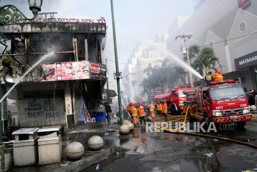 Petugas memadamkan api ruko yang terbakar saat unjuk rasa tolak Omnibus Law UU Ciptaker di Malioboro, Yogyakarta, Kamis (8/10).