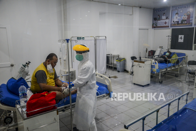 Petugas kesehatan saat merawat pasien Covid-19 di Rumah Sakit Lapangan Kota Bogor, Kompleks GOR Pajajaran, Kota Bogor, Jawa Barat, Jumat (2/7). Rumah Sakit Lapangan Kota Bogor kembali dioperasikan untuk menurunkan ketersediaan tempat tidur rumah sakit rujukan pasien Covid-19 di Kota Bogor pasca terjadinya lonjakan peningkatan kasus Covid-19. Rumah sakit tersebut sudah menerima 8 pasien Covid-19 rujukan dari RSUD Kota Bogor dengan kapasitas 18 tempat tidur untuk pasien covid-19 bergejala sedang. Republika/Putra M. Akbar