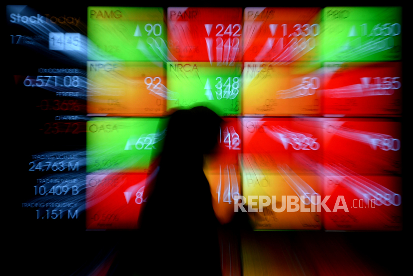 Karyawan berjalan di dekat layar pergerakan saham di gedung Bursa Efek Indonesia (BEI), Jakarta. ilustrasi. Prayogi/Republika.