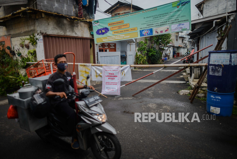 Warga melintasi spanduk zona merah yang terpasang di salah satu akses masuk wilayah RW 03 Kelurahan Kebon Manggis, Jakarta, Rabu (15/7). Jumlah rukun warga (RW) yang termasuk Wilayah Pengendalian Khusus (WPK) zona merah COVID-19 bertambah sebanyak tiga RW menjadi 30 RW yang tersebar di beberapa daerah di DKI Jakarta. (ilustrasi)