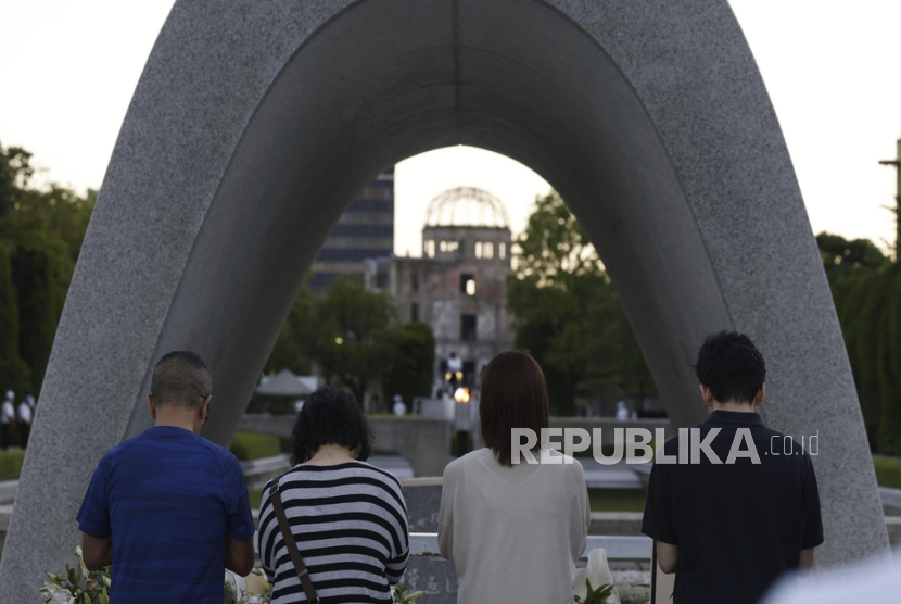 Visitors pay in front of the cenotaph dedicated to the victims of the atomic bombing at the Hiroshima Peace Memorial Park in Hiroshima, western Japan Sunday, Aug. 6, 2023. Hiroshima marked the 78th anniversary of the world
