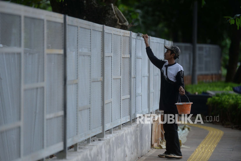 Pekerja mengecat pagar yang telah dipasang di Tebet Eco Park, Kecamatan Tebet, Jakarta Selatan, Senin (12/12/2022).