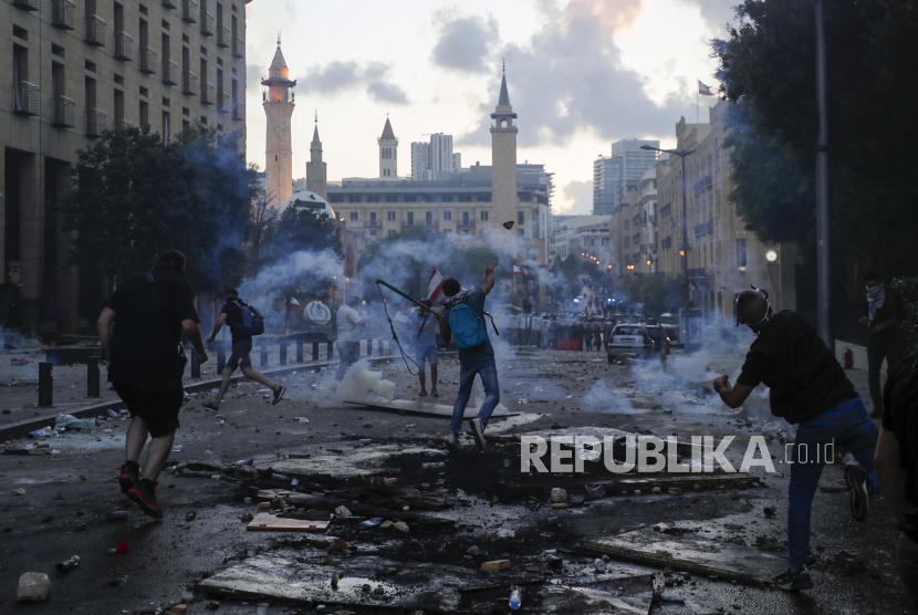  Orang-orang bentrok dengan polisi selama protes terhadap elit politik dan pemerintah setelah ledakan mematikan minggu ini di pelabuhan Beirut yang menghancurkan sebagian besar ibu kota dan menewaskan lebih dari 150 orang, di Beirut, Lebanon, Sabtu, 8 Agustus 2020. 