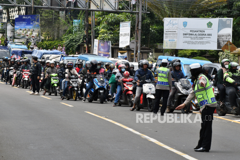 Anggota Satlantas Polres Bogor mengatur lalu lintas di jalan raya Puncak, Gadog, Kecamatan Ciawi, Kabupaten Bogor.