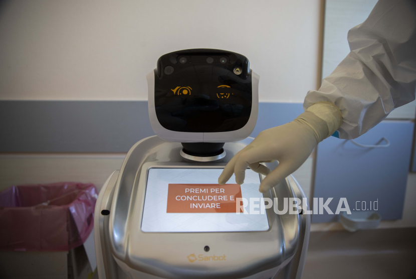 Petugas kesehatan menyiapkan robot di rumah sakit Circolo di Varese, Italia, Rabu (8/4). Enam robot membantu petugas kesehatan dalam membantu pasien Covid-19. 