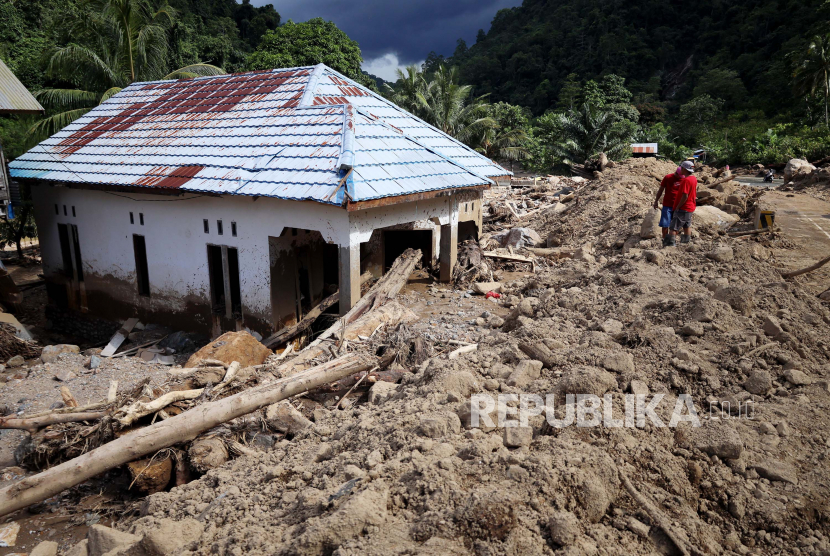Warga melihat rumah yang terkena longsor akibat banjir bandang di Desa Sondoang, Kecamatan Kalukku, Mamuju, Sulawesi Barat, Jumat (14/10/2022). Berdasarkan data sementara Badan Penanggulangan Bencana Daerah (BPBD) Kabupaten Mamuju sebanyak enam rumah hanyut, dua rumah tertimbun longsor, dan 13 rumah rusak berat serta 1.625 kepala keluarga dengan 5.273 jiwa terdampak musibah tersebut. Bencana Hidrometeorologi Kini tak Kenal Musim, Warga Diingatkan Selalu Waspada