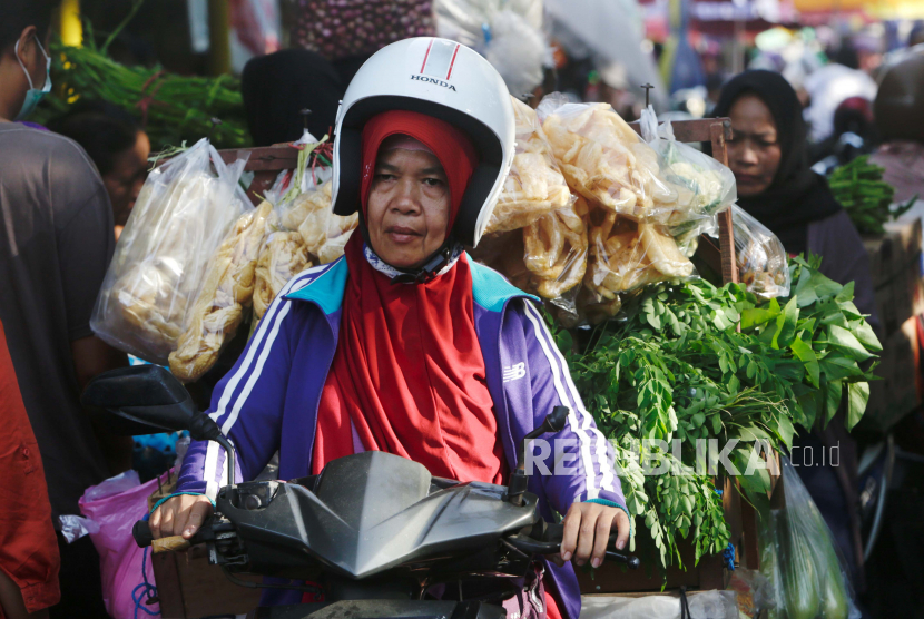 Seorang pedagang membawa makanan dan sayuran dengan sepeda motornya di sebuah pasar tradisional di Cianjur, Jawa Barat.