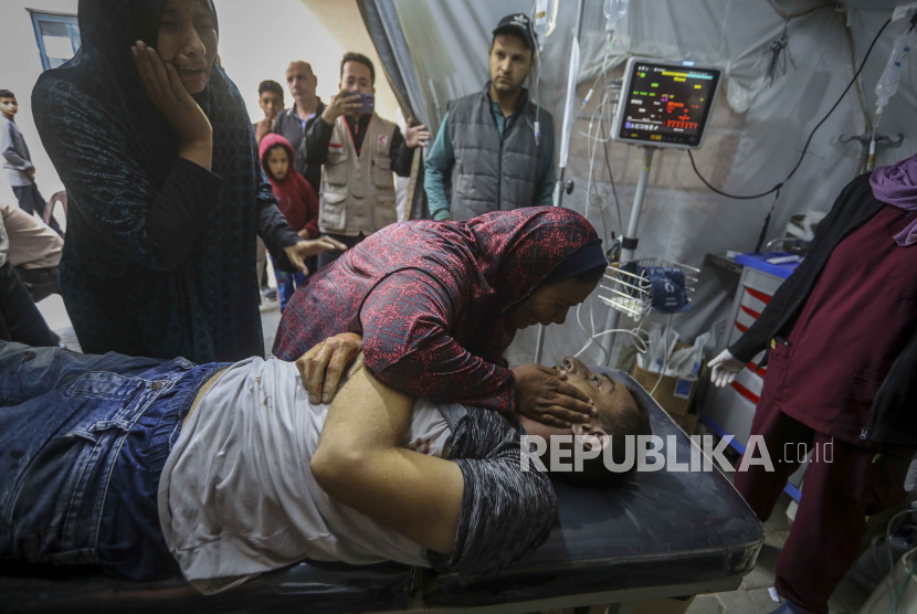 Warga Palestina berduka atas kematian kerabat mereka dalam pemboman Israel di Jalur Gaza, di sebuah rumah sakit di Rafah, Gaza. 