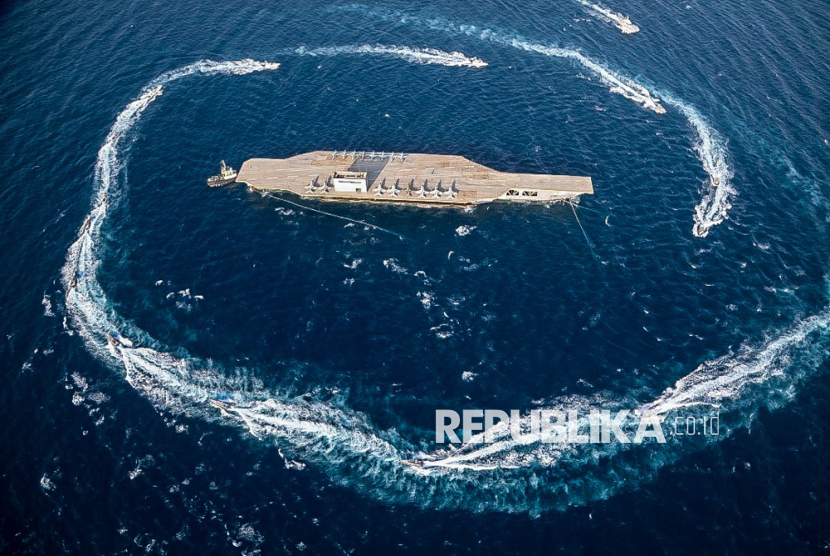 Kapal tempur militer Iran mengelilingi kapal induk tiruan selama latihan perang di Selat Hormuz, selatan Iran, 28 Juli 2020.