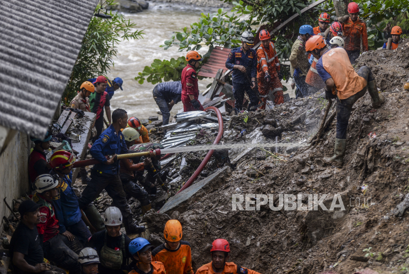 Petugas gabungan menyemprotkan air untuk mencari korban yang tertimbun tanah longsor di Kampung Sirnasari, Kelurahan Empang, Kecamatan Bogor Selatan, Kota Bogor, Jawa Barat, Rabu (15/3/2023). 