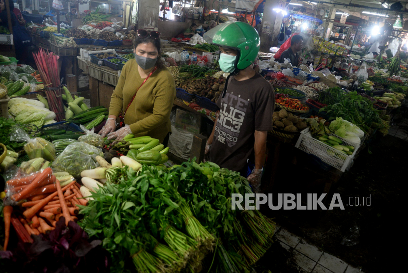 Pedagang sayur mayur melayani pembeli di Pasar Minggu, Jakarta, Senin (30/3). Kementerian Pertanian (Kementan) memastikan distribusi pangan nasional dapat berjalan lancar di tengah wabah virus corona (Covid-19), selain itu Kementan pun selalu memastikan agar stok dan produksi ada di sektor hulu