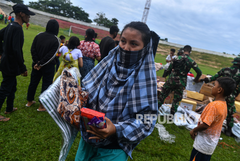 Pengungsi korban gempa membawa bantuan logistik dari TNI AD di Stadion Manakarra, Mamuju, Sulawesi Barat, Ahad (17/1/2021). Berdasarkan data BNPB per 17 Januari pukul 14.00 WIB, jumlah korban meninggal dunia akibat gempa bumi magnitudo 6,2 di Sulawesi Barat telah mencapai 73 orang.