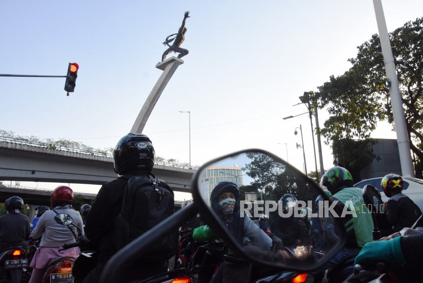 Pengendara sepeda motor berhenti saat lampu merah menyala di kawasan Pancoran, Jakarta, Jumat (21/8/2020). 