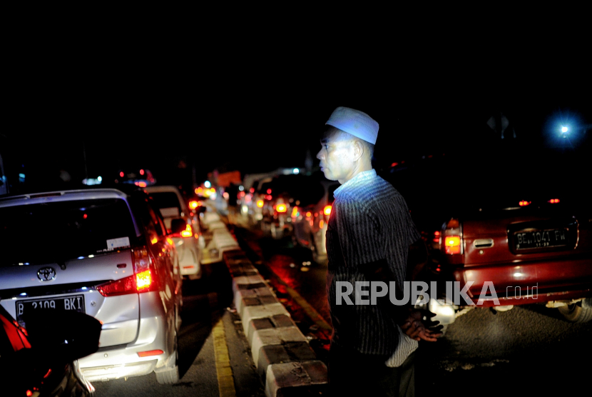 Pemudik beristirahat saat terjebak kemacetan di Jalan Alternatif Tol Merak Atasl,  Banten, Kamis (28/4/2022). Polda Banten memberlakukan skenario merah saat puncak arus mudik.