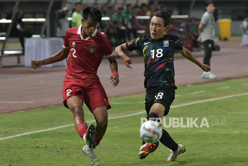 Pesepak bola timnas Indonesia U-17 Rizdjar Nurviat (kiri) diadang pemain timnas U-17 Korea Selatan You Minjun pada laga uji coba internasional di Bekasi, Jawa Barat, Rabu (30/8/2023) malam.