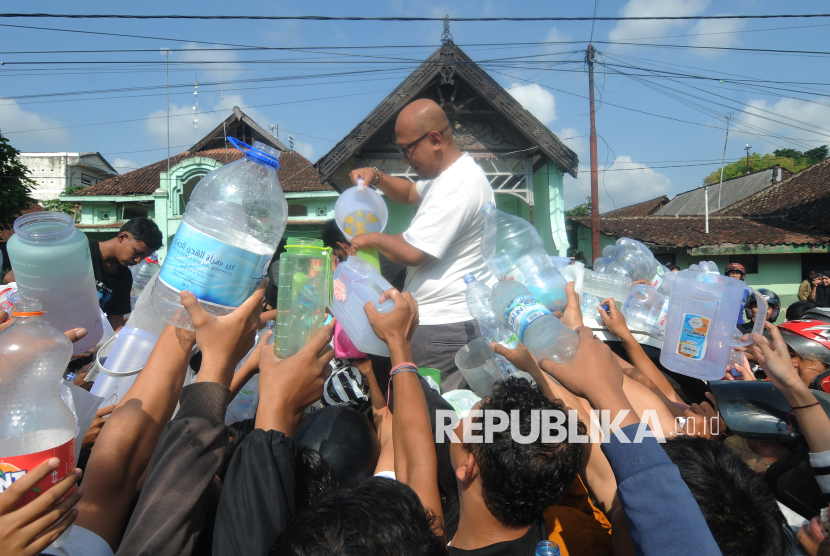 Seorang peloper susu membagikan susu sapi gratis kepada warga di Boyolali, Jawa Tengah, Sabtu (9/11/2024). Sebanyak 1.000 liter susu sapi dibagikan secara gratis karena sejak beberapa hari ini susu sapi dari peternak yang dibeli oleh peloper tidak dapat tertampung ke industri pengolahan susu karena berlimpahnya produk susu. 