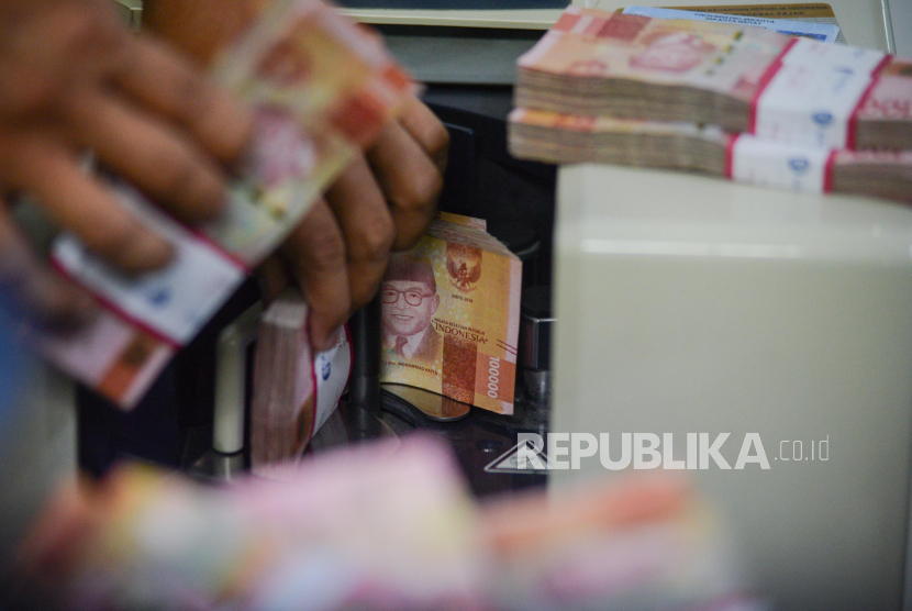 Petugas menghitung uang di Jakarta, Kamis (19/3). Pemerintah mencatat sebanyak 10 lembaga yang memiliki anggaran terkecil dalam APBN 2024.