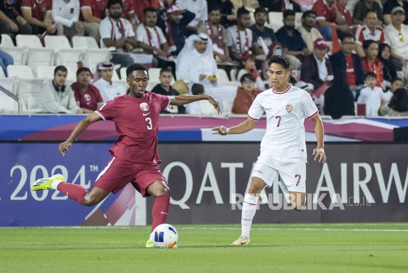 Pesepak bola Timnas U-23 Indonesia Marselino Ferdinan (kanan) membayangi pergerakan dari pesepak bola Timnas U-23 Qatar Saifeldeen Hassan Fadlalla (kiri) pada Kualifikasi Grup A Piala Asia U-23 2024 di Stadion Jassim Bin Hamad, Doha, Qatar, Senin (15/4/2024). Indonesia kalah dengan skor 0-2. Gol Qatar dicetak Khaled Ali dari titik putih di menit ke-43 dan tendangan bebas Ahmed Al Rawi menit ke-54. Pada laga itu dua pemain Indonesia Ivar Jenner dan Ramadhan Sananta mendapat kartu merah dari wasit. 