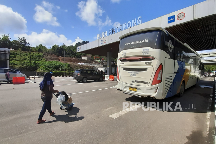 Seorang pelintas batas yang masuk dari Malaysia mendorong tas bawaannya di Pos Lintas Batas Negara (PLBN) Entikong di Kabupaten Sanggau, Kalimantan Barat, Selasa (17/3/2020). 