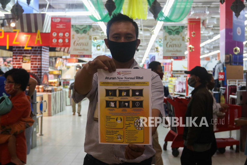 Pegawai swalayan Carrefour menunjukkan poster sebelum ditempelkan di BG Junction, Surabaya, Jawa Timur, Rabu (27/5/2020). Penempelan poster yang berbunyi 