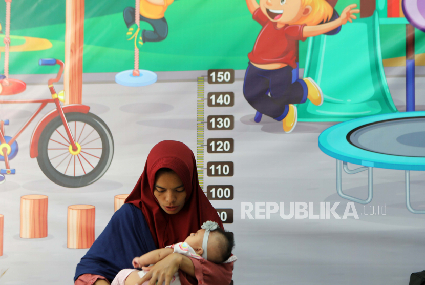 Seorang ibu menunggu vaksinasi polio bersama anaknya di Puskesmas Banda Aceh, Senin, 21 November 2022. Angka Kelahiran di Aceh Turun dalam Lima Dekade