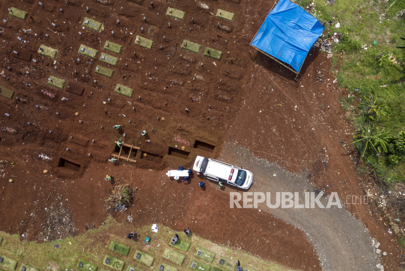 Petugas penggali makam jenazah COVID-19 bersiap menurunkan peti di komplek pemakaman Pondok Ranggon.