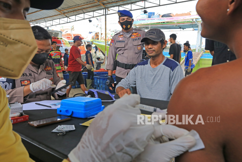 Sejumlah nelayan mengikuti vaksinasi COVID-19 usai melakukan bongkar muat ikan di tempat pelelangan ikan Karangsong, Indramayu, Jawa Barat, Senin (6/12/2021). Vaksinasi COVID-19 bagi nelayan itu digelar untuk mengejar herd immunity atau kekebalan kelompok tuntas pada Desember 2021 dengan target 32 juta jiwa untuk wilayah Jawa Barat. 