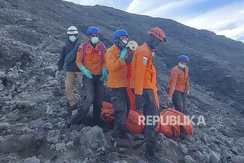 A handout photo made available by the Indonesian rescue agency (BASARNAS) shows rescuers preparing to evacuate the body of a hiker killed in the Mount Marapi eruption in Agam, West Sumatra, Indonesia, 05 December 2023. Search and rescue operations continue following the eruption. At least 13 hikers were found dead and 10 others went missing after the Marapi volcano erupted on 03 December 2023, according to the Indonesian rescue agency.  