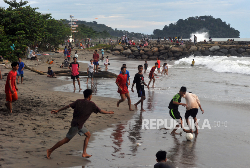 Sejumlah warga bermain bola di Pantai Padang, Sumatera Barat, Ahad (1/11). Industri perjalanan dan pariwisata global akan kehilangan 174 juta pekerjaan tahun ini apabila pembatasan aktivitas sosial dan ekonomi terus diberlakukan di banyak negara. 