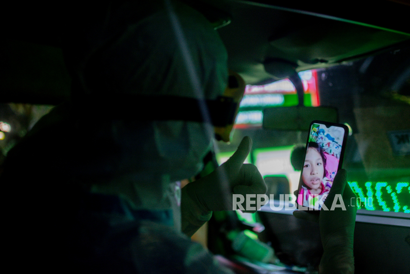 Petugas melakukan panggilan video sebelum mengevakuasi pasien Covid-19 menuju RSDC Wisma Atlet Kemayoran, di Puskesmas Kecamatan Pasar Minggu, Jakarta, Selasa (29/6). Seiring dengan peningkatan kasus harian Covid-19, Pemerintah berencana akan memberlakukan kebijakan Pemberlakukan Pembatasan Kegiatan Masyarakat (PPKM) Darurat  melalui rapat terbatas yang dipimpin Presiden Joko Widodo pada Selasa 29 Juni 2021. Kebijakan tersebut rencananya akan diterapkan selama dua minggu di zona merah Covid-19. Republika/Thoudy Badai