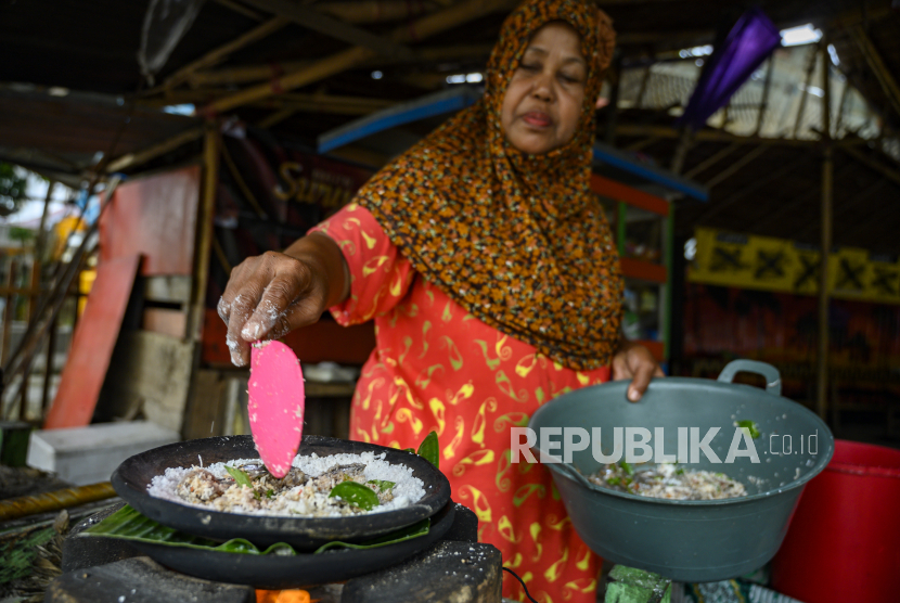 Seorang ibu memasak makanan ambal khas Tolitoli di Kelurahan Baru, Kabupaten Tolitoli, Sulawesi Tengah, Senin (7/9/2020). Ambal adalah makanan tradisional suku Tolitoli yang terbuat dari sagu dicampur dengan parutan kelapa yang dibakar bersama ikan kecil yang dialasi dengan daun pisang. 