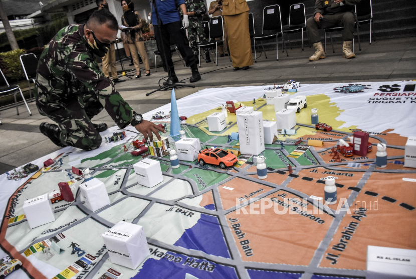 Anggota TNI mengikuti simulasi taktis permainan lantai (Tactical Floor Game) saat simulasi penerapan Pembatasan Sosial Berskala Besar (PSBB) Kota Bandung di Plaza Balai Kota Bandung, Jalan Wastukencana, Kota Bandung, Senin (20/4). Simulasi yang diikuti oleh TNI, Polisi, Satpol PP, Dinas Kebakaran dan Penanggulangan Bencana, Dinas Kesehatan dan Dinas Perhubungan tersebut bertujuan untuk mengecek kesiapan petugas sekaligus menentukan titik lokasi pemeriksaan PSBB yang rencananya akan digelar pada Rabu (22/4)