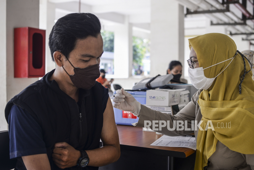 Tenaga kesehatan menyuntikan vaksin Covid-19 kepada warga di Rusun KS Tubun, Palmerah, Jakarta, Selasa (5/7/2022). Pemerintah akan memberlakukan vaksin booster sebagai syarat perjalanan dan kegiatan masyarakat yang mulai diterapkan dalam waktu dua minggu lagi untuk mencegah kenaikan kasus Covid-19. 