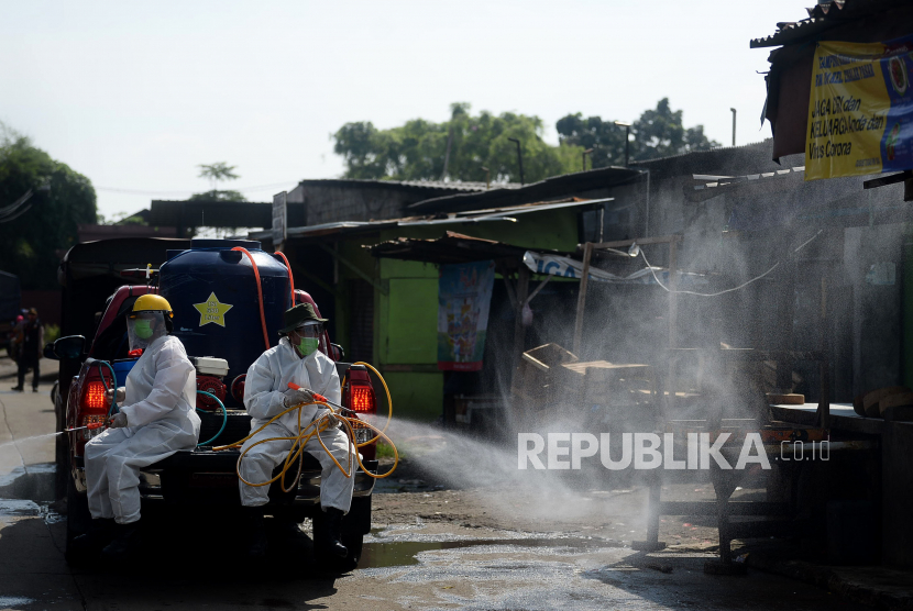 Petugas menyemprotkan cairan disinfektan di area pasar.