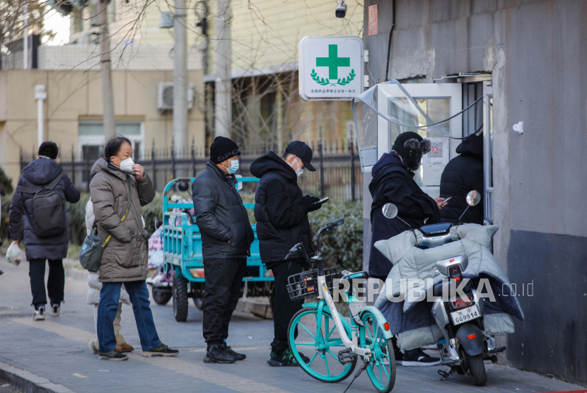 Orang-orang mengantre untuk membeli obat di Beijing, China, 21 Desember 2022. Pihak berwenang China telah melaporkan lima kematian lagi karena klinik demam atau ruang konsultasi dan tempat tidur rumah sakit telah disiapkan di seluruh negeri. Kasus Covid-19 terus menyebar saat Beijing melonggarkan langkah-langkah pengendalian pandemi.