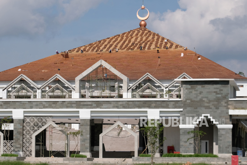 Sejumlah pekerja menyelesaikan pemasangan atap pada proyek pembangunan Masjid Agung Jawa Tengah (MAJT) Magelang, di Sawitan, Mungkid, Magelang, Jawa Tengah, Selasa (19/12/2023). Pembangunan masjid berkonsep Islamic Center seluas 4,9 hektare dengan anggaran pembangunan sebesar Rp120 miliar tersebut diharapkan menjadi destinasi wisata religi pelengkap Candi Borobudur. 