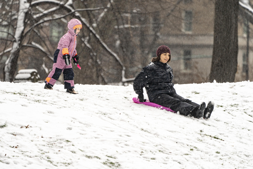 Orang-orang bermain salju di Central Park, New York, AS.