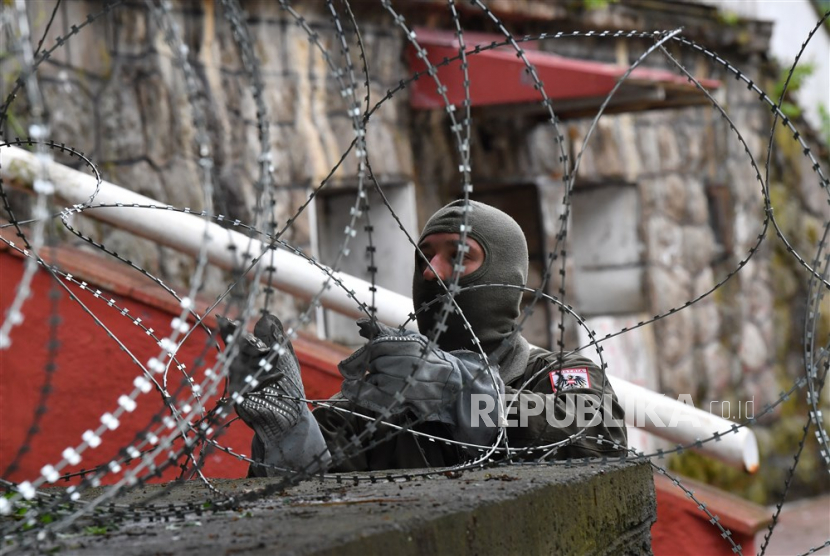 Seorang prajurit kontingen Austria dari Pasukan penjaga perdamaian internasional NATO di Kosovo (KFOR) memasang pagar kawat berduri di depan gedung kotamadya di Zvecan, Kosovo, 31 Mei 2023.