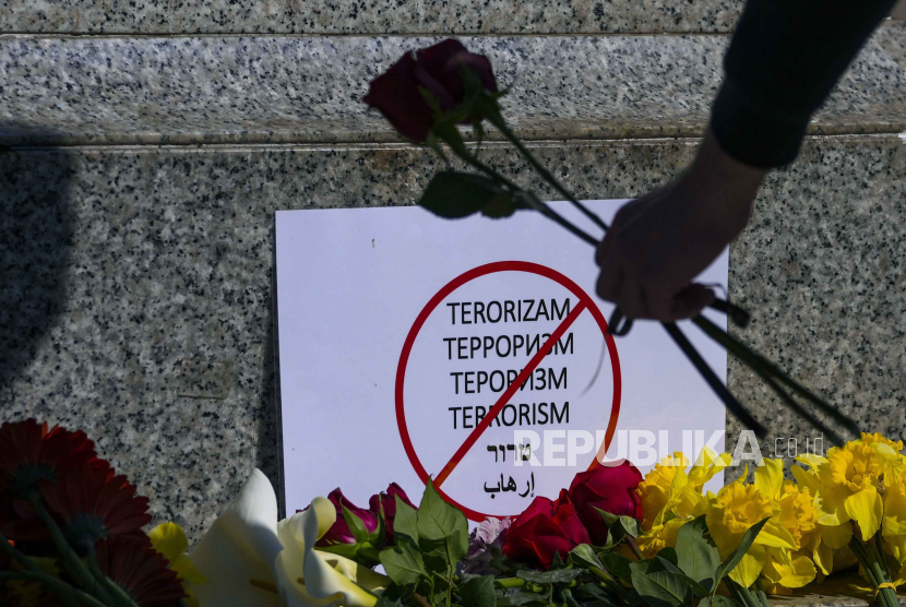 Seorang wanita meletakkan bunga di monumen penyair terkenal Rusia Aleksander Pushkin di Beograd, Serbia, Sabtu, (23/3/2024), menyusul serangan hari Jumat di Balai Kota Crocus di tepi barat Moskow. 