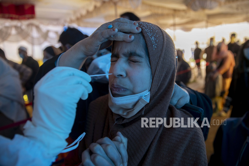  Seorang petugas kesehatan mengambil sampel usap hidung seorang gadis Kashmir untuk diuji COVID-19 di Srinagar, Kashmir yang dikendalikan India, Rabu, 21 April 2021. 