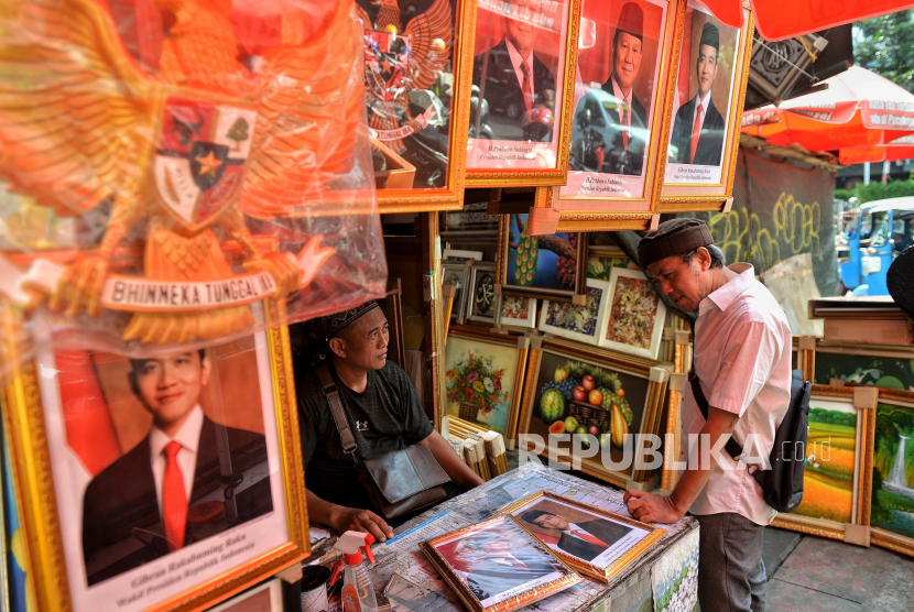 Traders served buyers of photo frames of Prabowo-Gibran as President and Vice President 2024-2029 in Pasar Baru area, Jakarta, Tuesday (23/4/2024). Traders claimed that the sale of photo frames of the President and Vice President-elect began to be sought after a number of customers after the Constitutional Court (MK) decided to reject the disputed presidential election petition filed by Anies-Muhaimin and Ganjar-Mahfud MD. He admitted that sales have increased by up to 30 percent with prices ranging from IDR 150 thousand to Rp20 million depending on size. Meanwhile, the KPU will determine the presidential and vice president-elect for 2024 elections at the Central Commission building, Jakarta on Wednesday (24/4/2024) tomorrow.