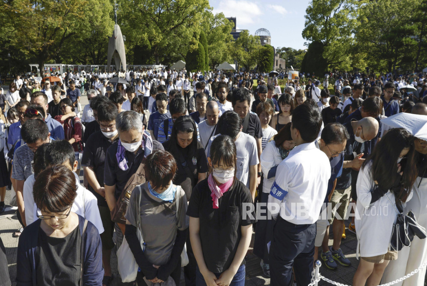 Visitors observe a moment of silence during a ceremony marking the 78th anniversary of the world