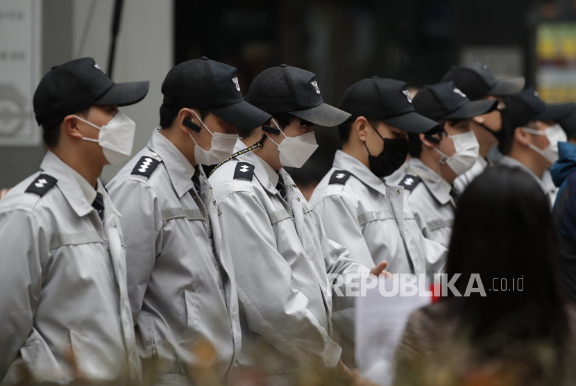  Petugas keamanan yang mengenakan masker untuk membantu mengekang penyebaran virus korona di luar Balai Kota Seoul di pusat kota Seoul, Korea Selatan, Rabu, 18 November 2020. 